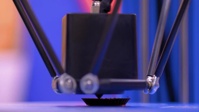 Print head of 3D printer machine printing plastic model at modern scifi technology exhibition, factory - close up. 3D printing, additive technologies, 4.0 industrial revolution and futuristic concept