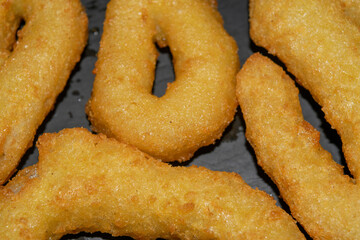 Homemade onion rings on a black table. Close up.