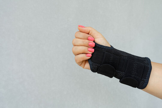 Close up of woman's hand wearing supportive orthopedic wrist brace in and copy space