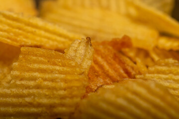 Corrugated potato chips, the texture of the surface. Close up.