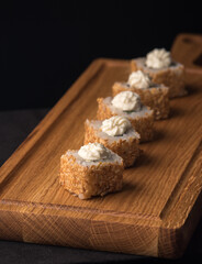 Sushi rolls with sesame seeds on a wooden dummy board. Vertical orientation. Japanese traditional cuisine concept.