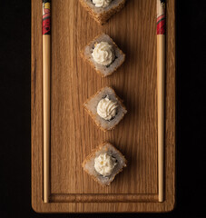 Sushi rolls with sesame seeds on a wooden sideboard. view from above. Japanese traditional cuisine concept.