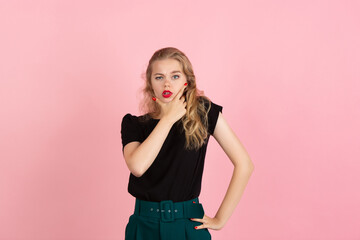 Thoughtful. Portrait of young emotional woman gesturing isolated on pink studio background. Human emotions, facial expression, sales, ad concept. Blonde caucasian pretty model gesturing. Copyspace.