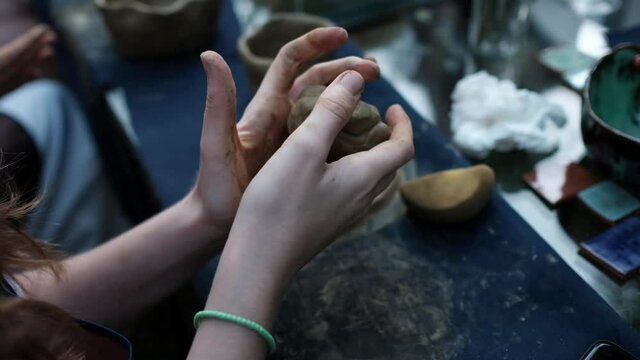 Human hands kneading clay, close-up. Pottery workshop concept.