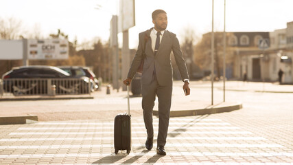 African Businessman With Travel Suitcase Crossing Road In City, Panorama