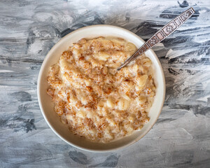 Oatmeal with milk in a deep plate on a black and white paper napkin