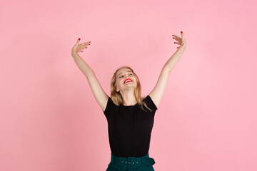 Happy. Portrait of young emotional woman gesturing isolated on pink studio background. Human emotions, facial expression, sales, ad concept. Blonde caucasian pretty model gesturing. Copyspace.