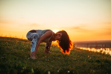 Yoga practice and meditation in nature in sunrise. Woman practicing near big river Kama.