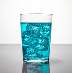 glass with ice and blue liquid