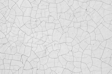 White peeling paint on the wall. Old concrete wall with cracked flaking paint. Weathered rough...