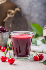 Homemade sweet and sour cherry jam with fresh cherries on light table, copy space