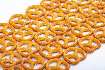 Background texture of salted savory mini pretzels in the traditional looped knot shape in a random heap viewed full frame from overhead
