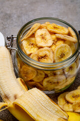 Healthy snack, crispy dehydrated unsugared banana chips in glass jar