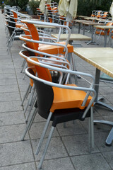 Stacked chairs one on another in front of restaurant outdoors in the morning