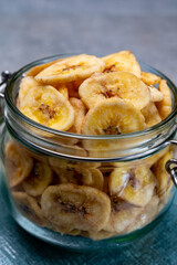Healthy snack, crispy dehydrated unsugared banana chips in glass jar