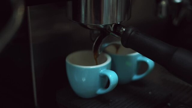 barista usando maquina de expresso con dos tazas en cafeter&iacute;a moderna