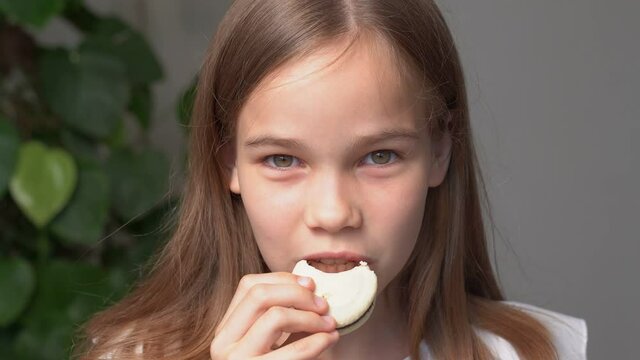 teen girl bites of macaron eating