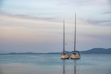 Two sailingboats moored and attached together in sunset with large copy space.