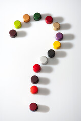 Screw cap wine bottle closures forming a question mark on a white backround.