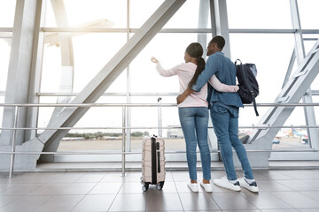 Post-Quarantine Travelling. Black Hugging Couple Looking At Airport Window, Rear View