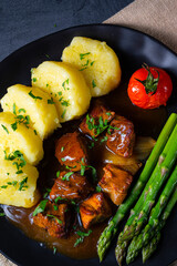 dumplings with beef goulash and green asparagus