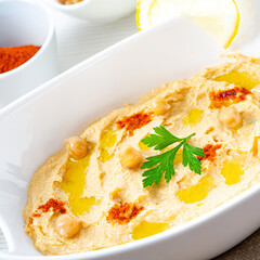 hummus paste with lemon and chilli on white background