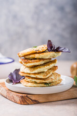 Vegetarian zucchini fritters or pancakes stack topped with sour cream and cilantro. Vegetable pancakes