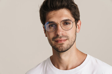 Obraz premium Image of confident young man in eyeglasses posing and looking at camera