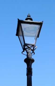 Traditional Iron Street Light seen from Below against Blue Sky 
