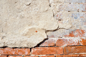 Empty old brick wall texture. Shabby facade of a building with damaged plaster.