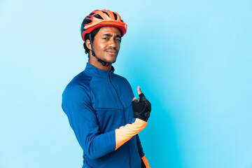 Young cyclist man with braids over isolated background proud and self-satisfied