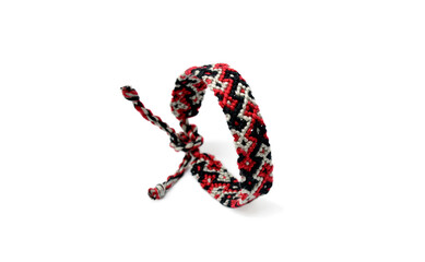 Selective focus of tied woven friendship bracelet with bright colorful pattern handmade of thread isolated on white background