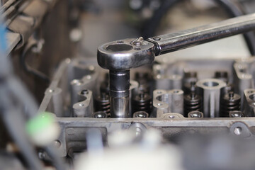 The mechanic is checking the engine.