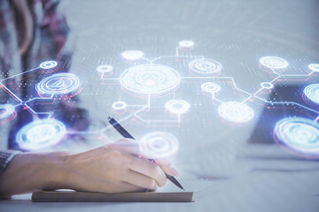 Social network theme hologram over hands taking notes background. Concept of global international people connect. Double exposure