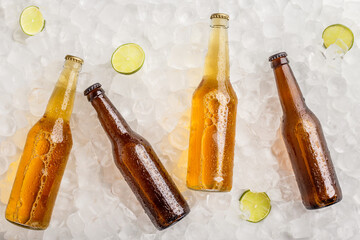 Various beers chilled for party. Cold glass bottles with beer in ice with lime