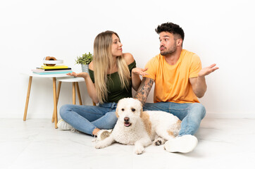 Young caucasian couple with dog staying at home having doubts