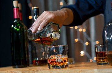 Pouring whiskey drinks on wood