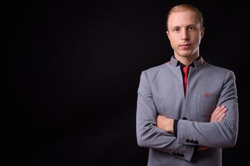 Businessman with blond hair against black background