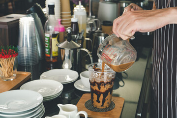 Barista is making drinks in the coffee shop.