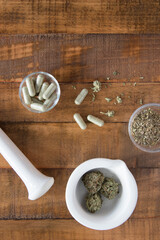 Cannabis with mortar and pestle including capsules, flat lay