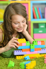 Portrait of girl playing with colorful plastic blocks