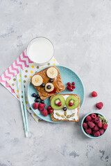 Obraz na płótnie Canvas Funny breakfast toast for kids shaped as cute dog, bear. Food art sandwich for child. Isolated. Animal faces toasts with spreads, fruits