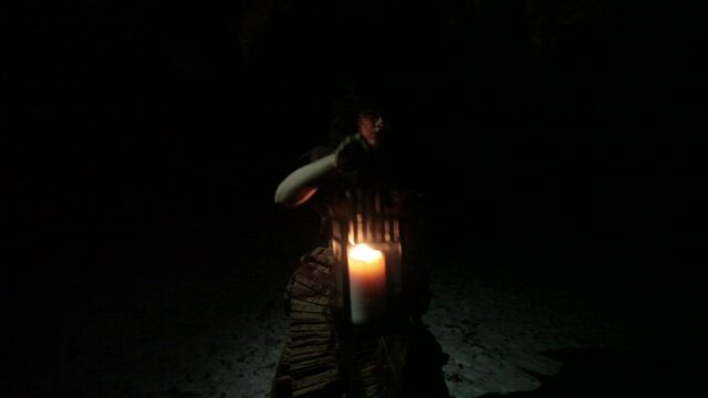 Woman in a Fancy dress Walking In the Dark Forest in the winter in the night holding a lantern.