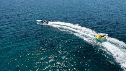 Fototapeta premium Aerial drone tracking photo of extreme power boat donut water-sports cruising in high speed in open ocean deep blue bay