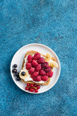 Funny breakfast toast for kids shaped as cute fish. Food art sandwich for child. Isolated. Animal faces toasts with spreads, fruits