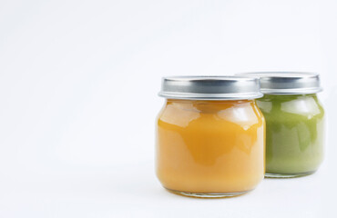 Baby vegetable or fruit puree in a glass jar on a white background. Baby food concept. Copy space