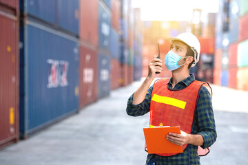 Industrial worker wear hygienic mask  at logistic warehouse container workplace,during quarantine and social distancing and new normal,prevent from covid-19 pandemic illness.