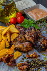 Delicious piece of meat served with potatoes decorated with dry tomatoes, pepper and herbs