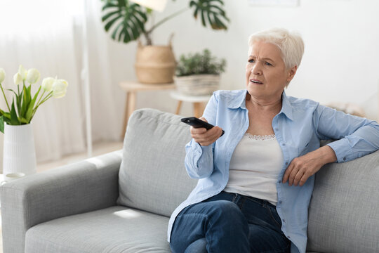 Breaking News. Shocked Senior Woman Watching Tv At Home, Sitting On Couch