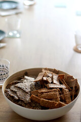 Two types of seed crackers, served in a big bowl on a table. Selective focus.